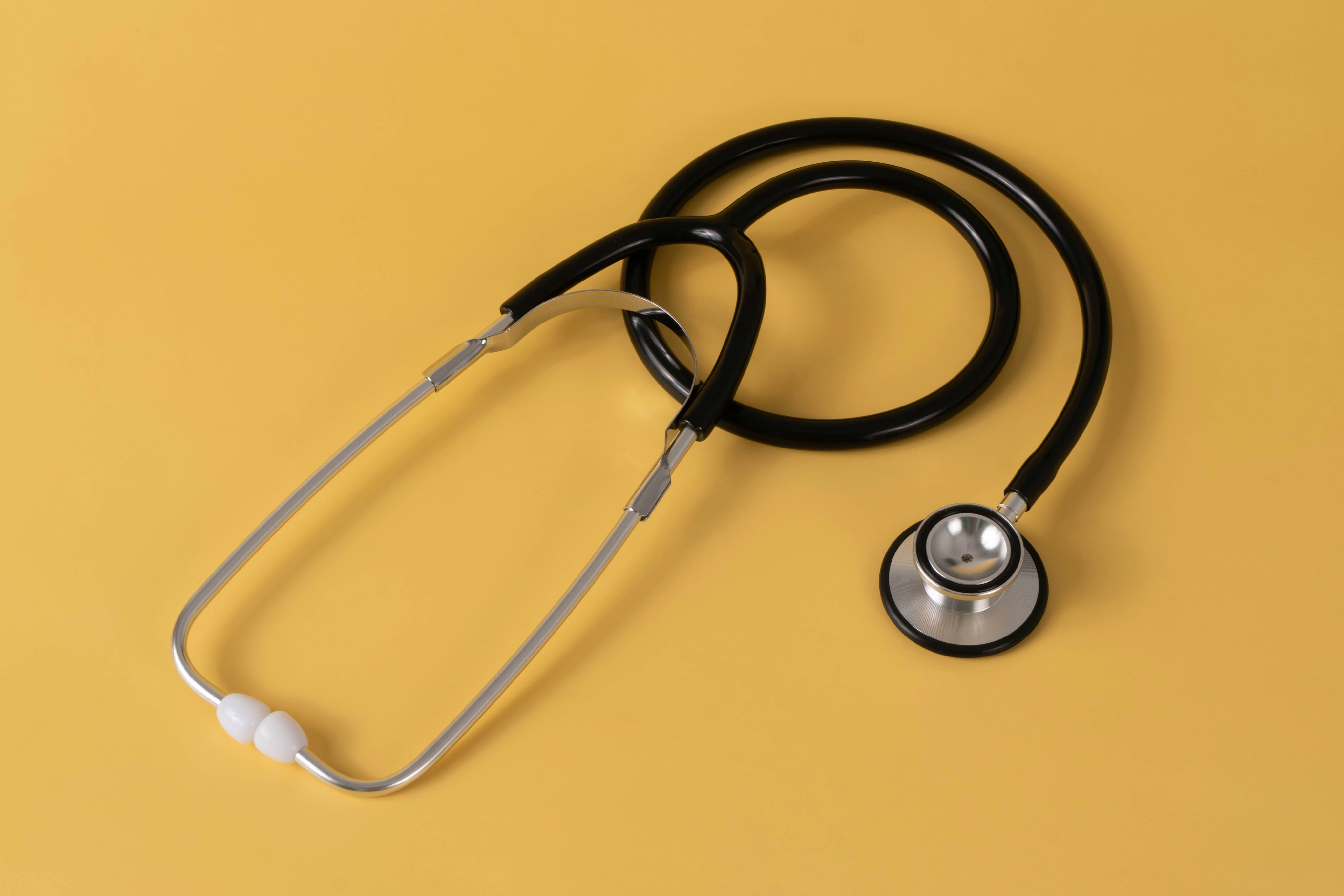 A stethoscope placed on a yellow background.